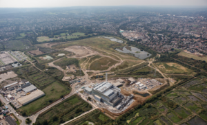 A photo of the Beddington landfill site. In the foreground is the Beddington Energy Recovery Facility (the facility was under construction at the time this image was taken and the 'construction village' pictured to the right of the facility has been removed). At the top of photo are the lakes which form part of the new nature reserve.