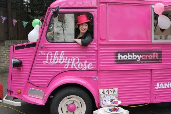 Image of Libby Rose in her bright pink van, from where she runs ‘Love Your Clothes’ sewing workshops.