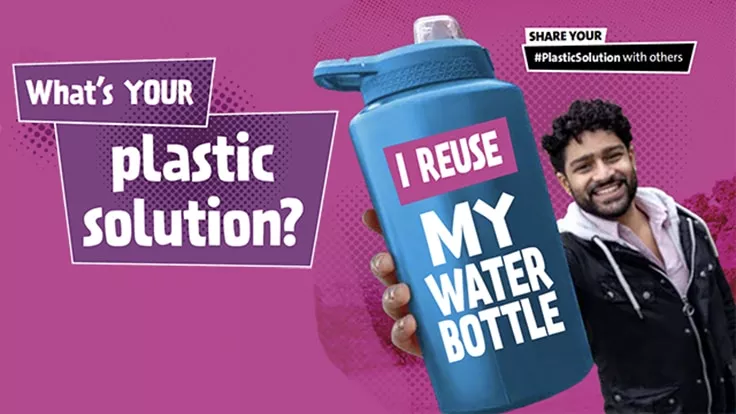 Man holding a water bottle with the words 'I reuse my water bottle' on it.